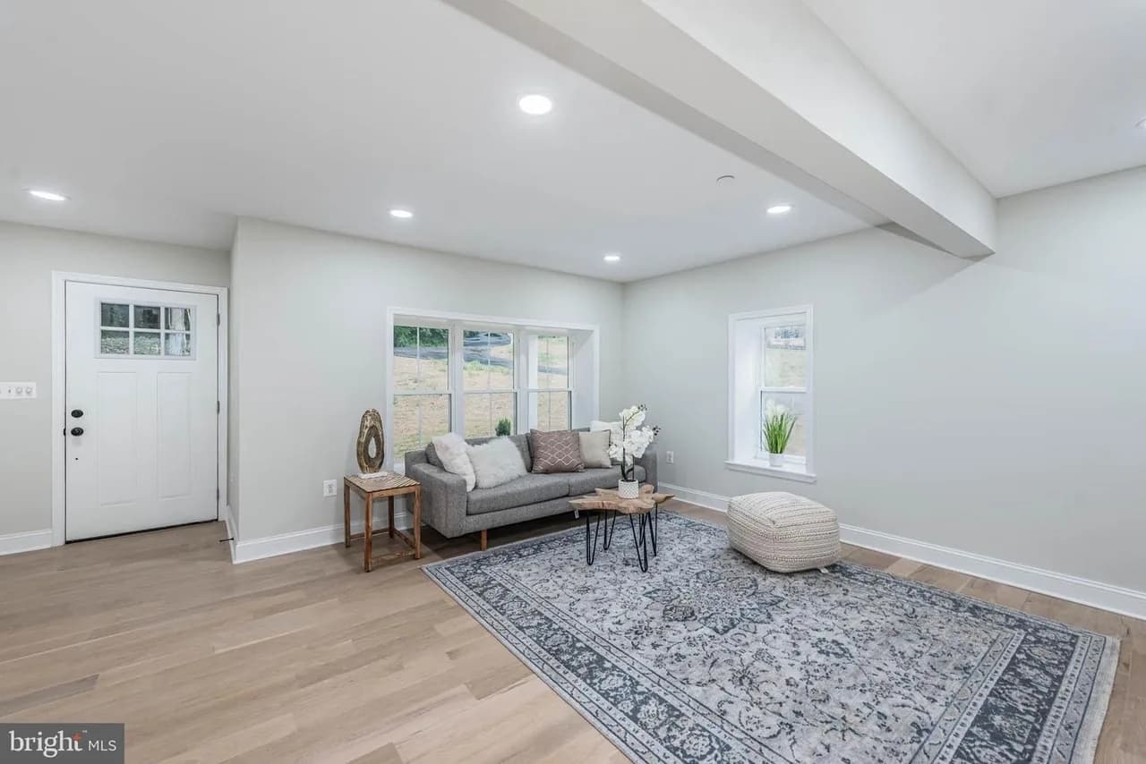Long Green Pike living room with broad windows, pale wood flooring and a grey sofa