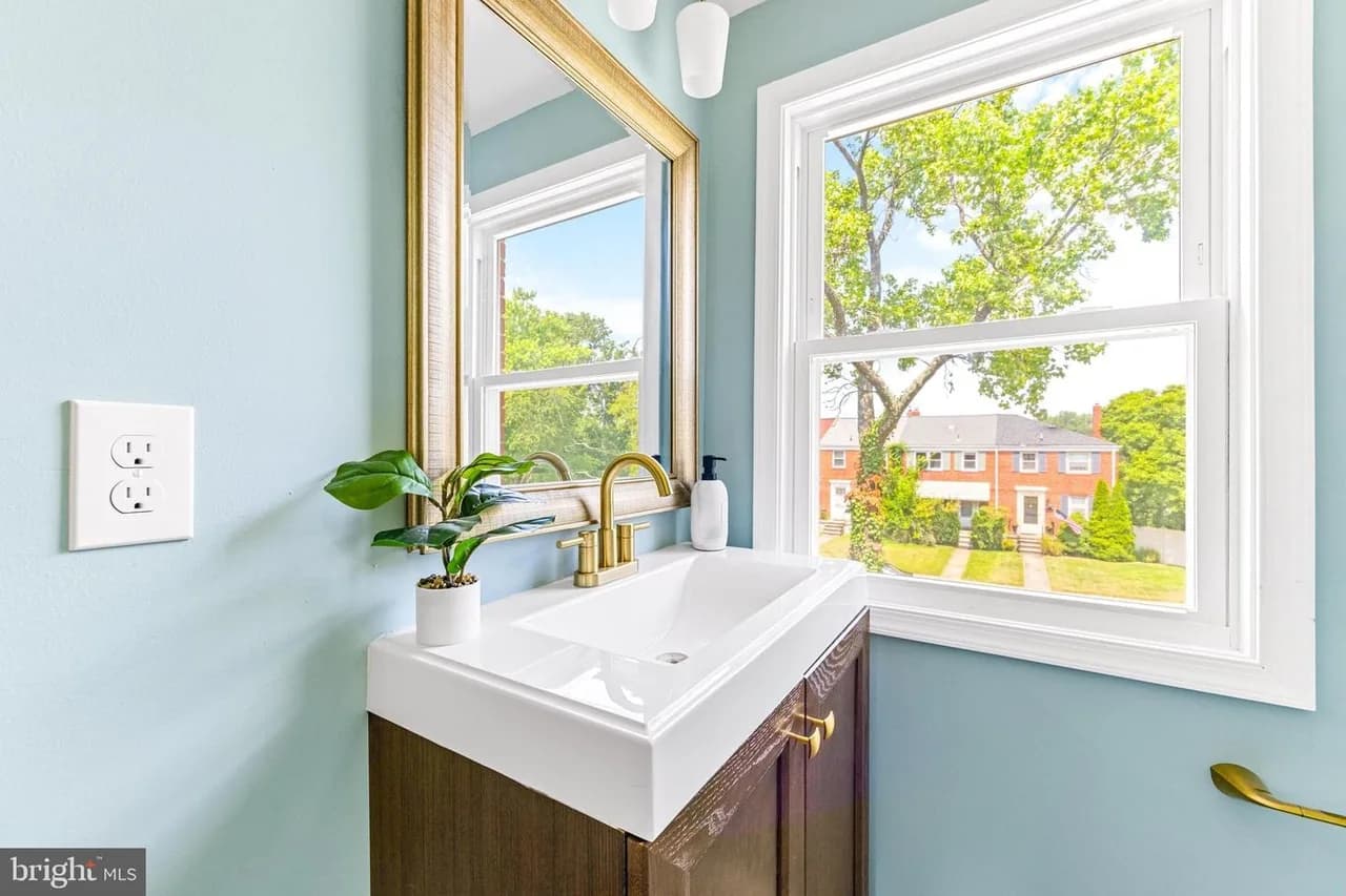 Joan Avenue bathroom with a light-blue wall and gold-tone faucet