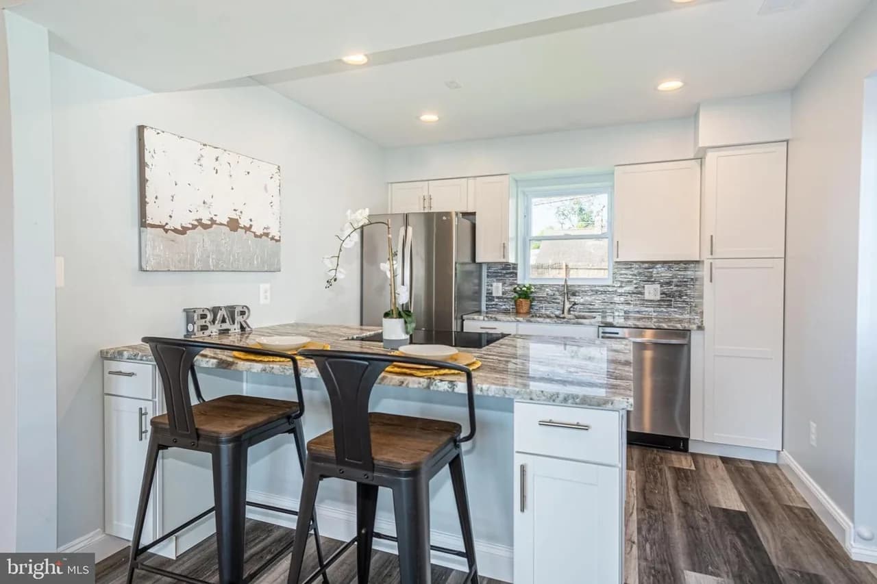 Baybriar kitchen with an island, white cabinets and patterned backsplash