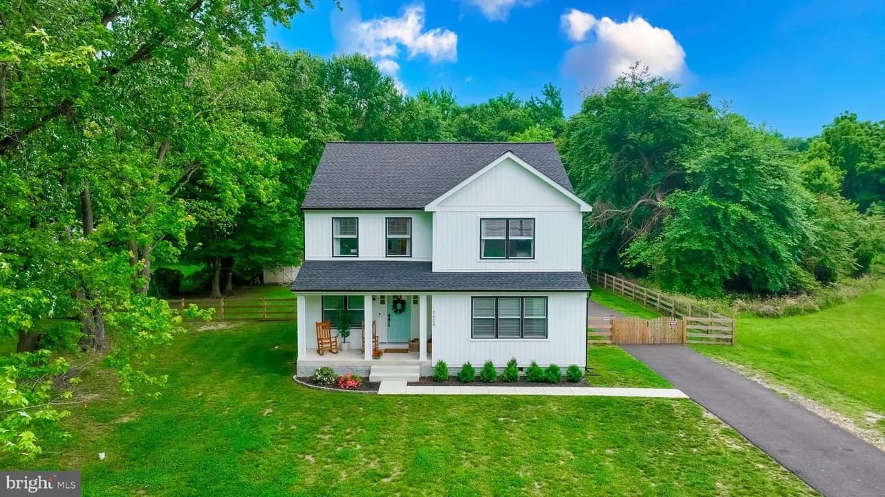 White two-story home at 3623 Glenwood Road with a covered porch and wooded setting