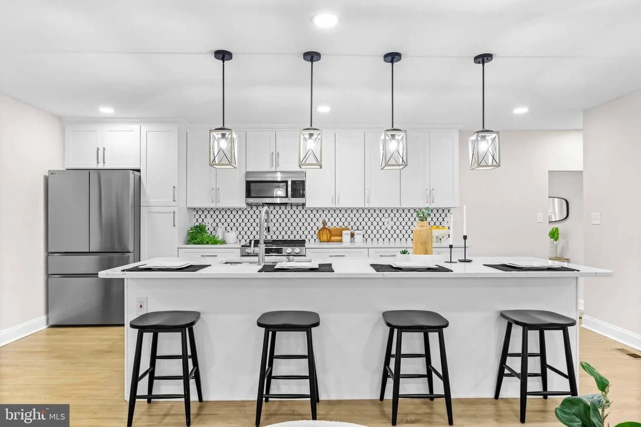Bramleigh kitchen with a central island, white cabinetry and pendant lights
