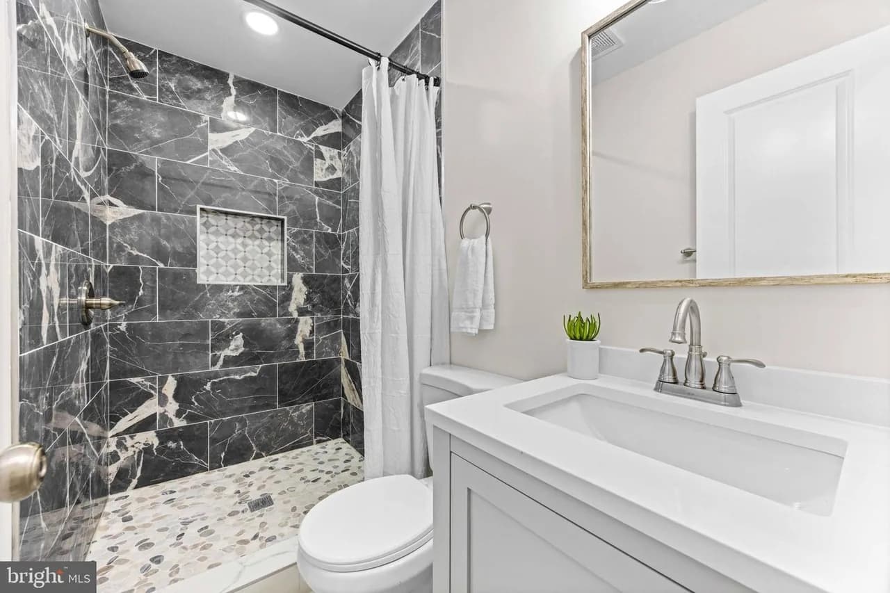 Bramleigh bathroom with a dark stone-pattern shower wall